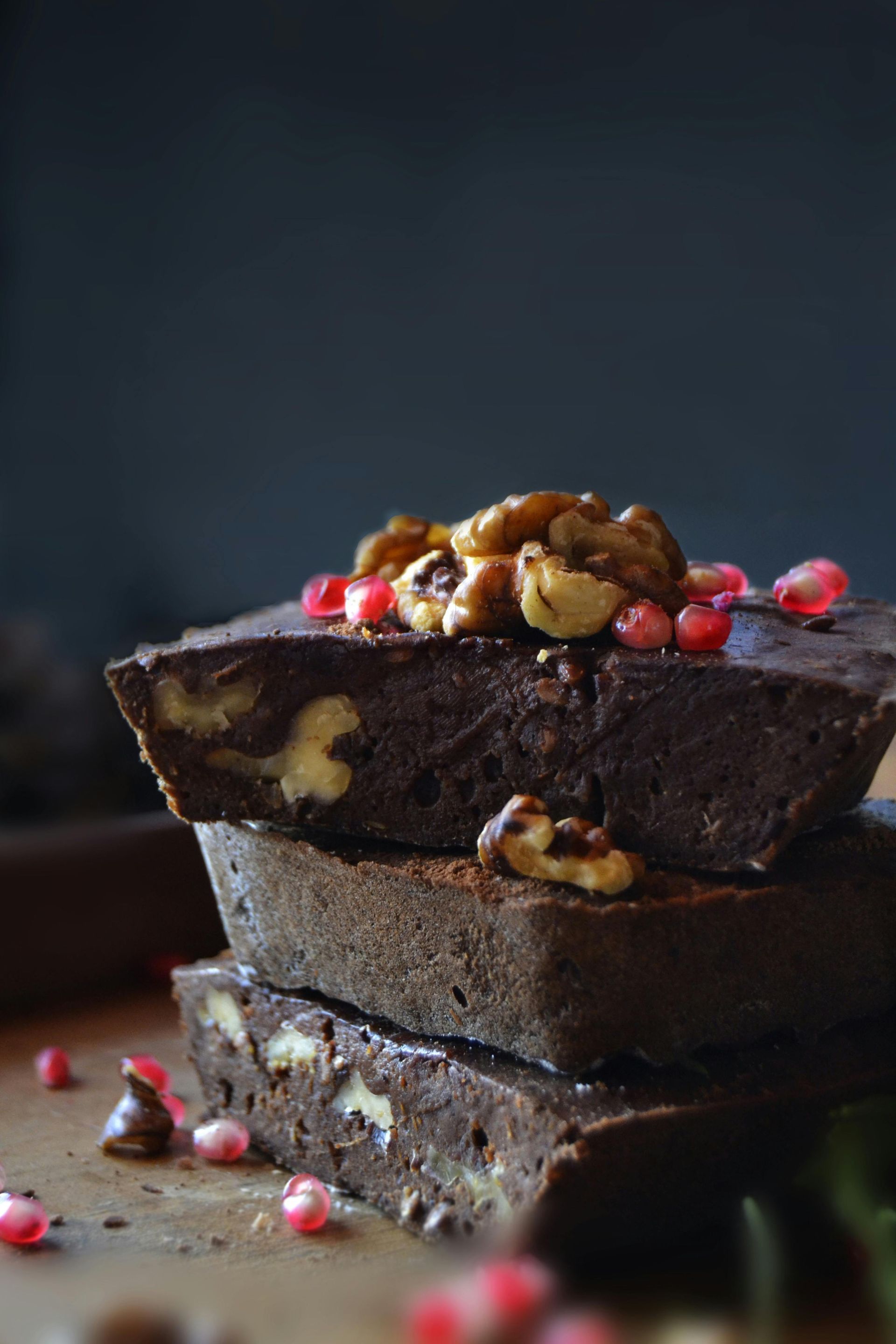 Chocolate fruit cake displayed with nuts and pomegranate 
