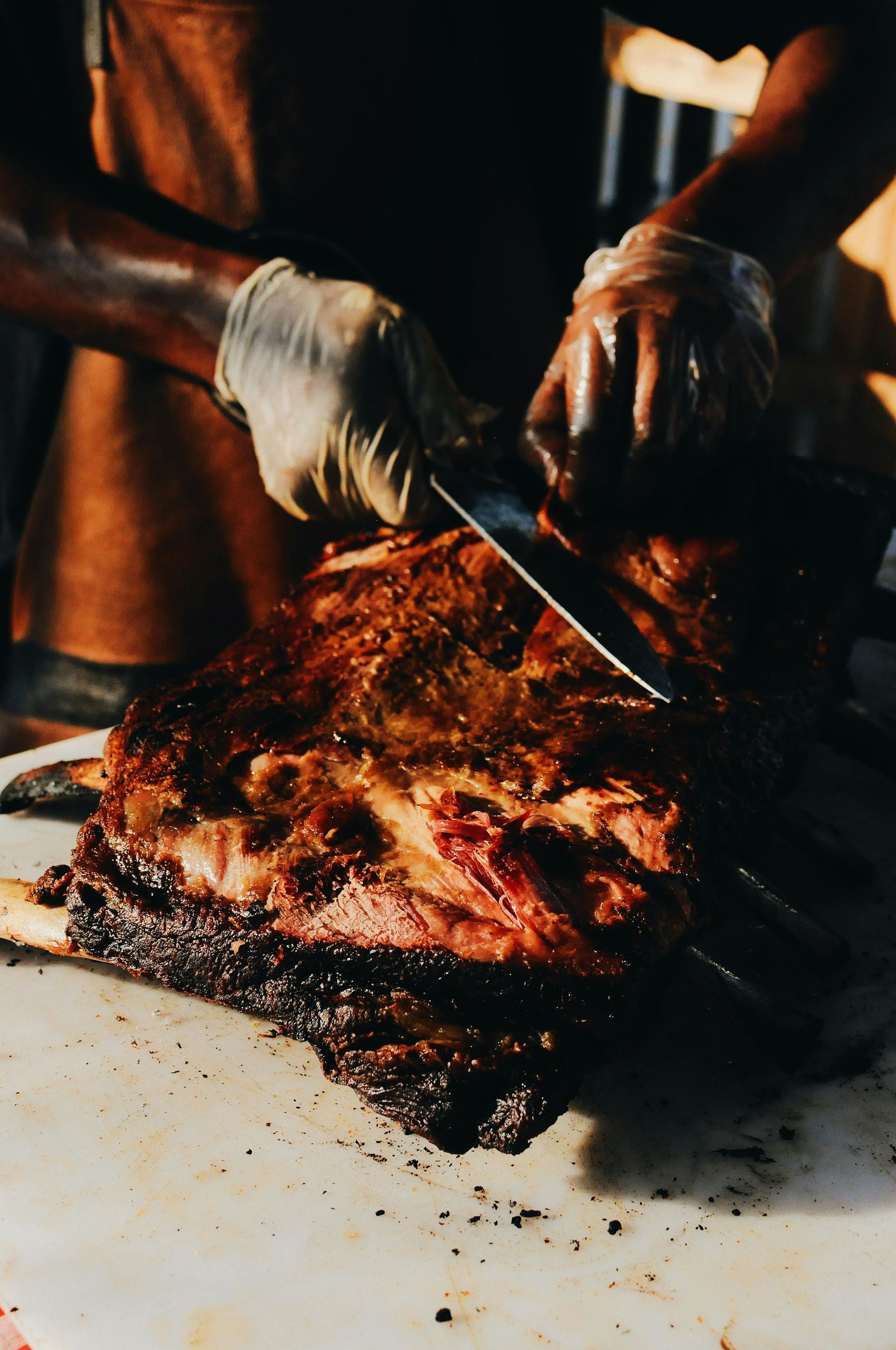 A large piece of steak being sliced into smaller pieces at a fine dining restaurant