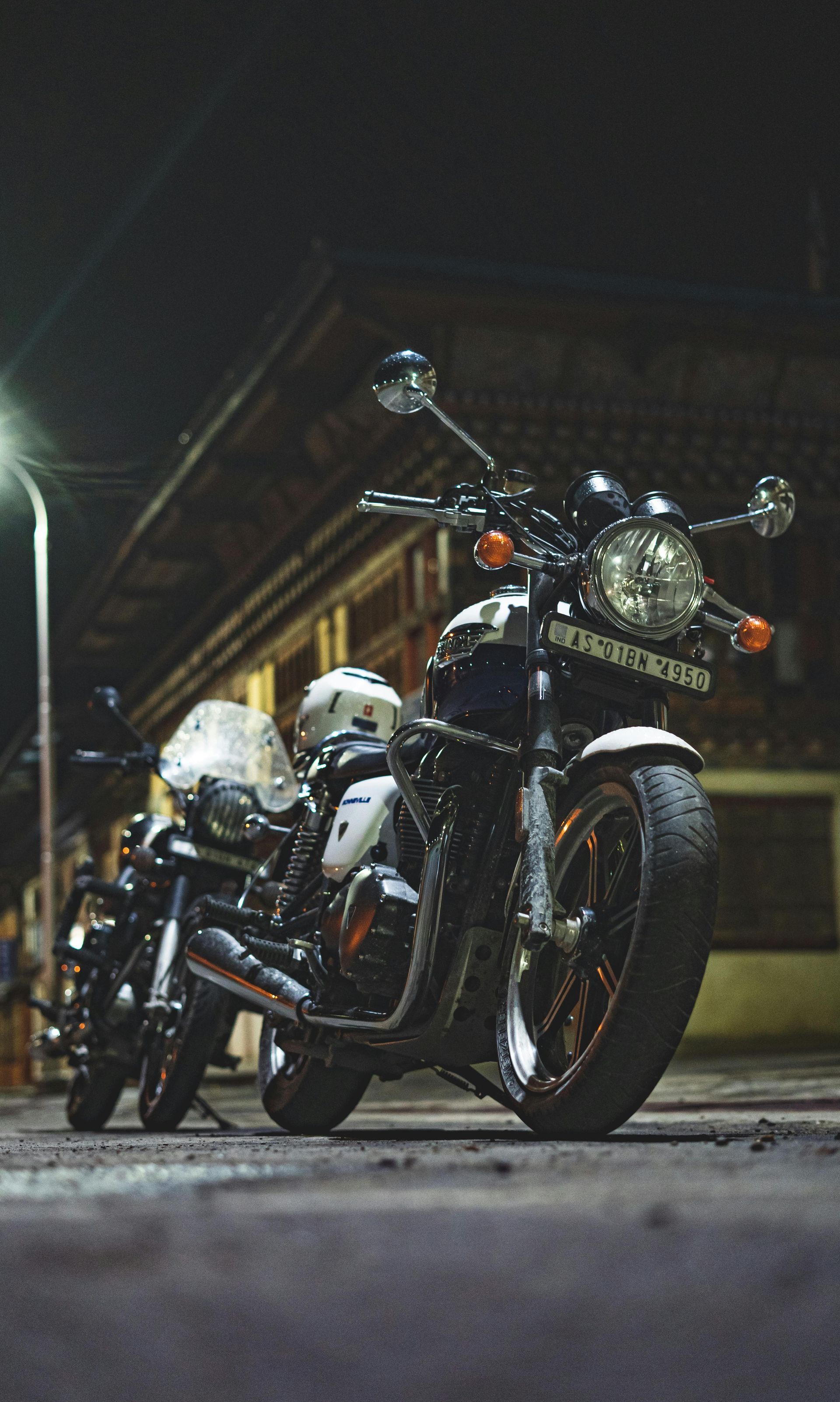 Motorcycles parked on the street on a quiet night