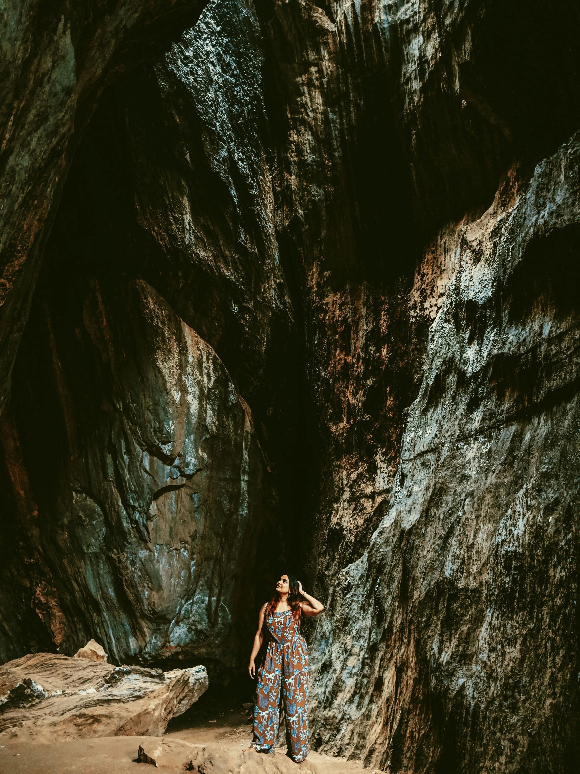 Dark rock cave with water coming through small crack of the rocks