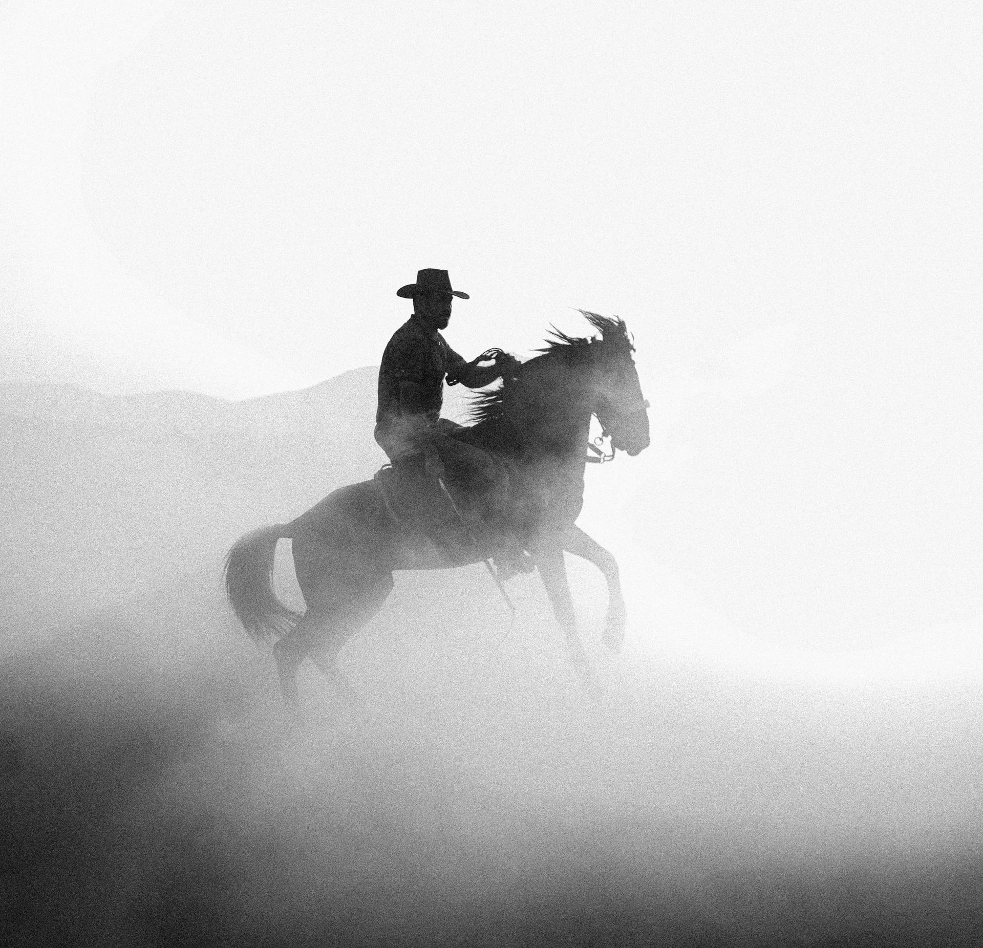 Old cowboy riding a horse on the open plains of the old west