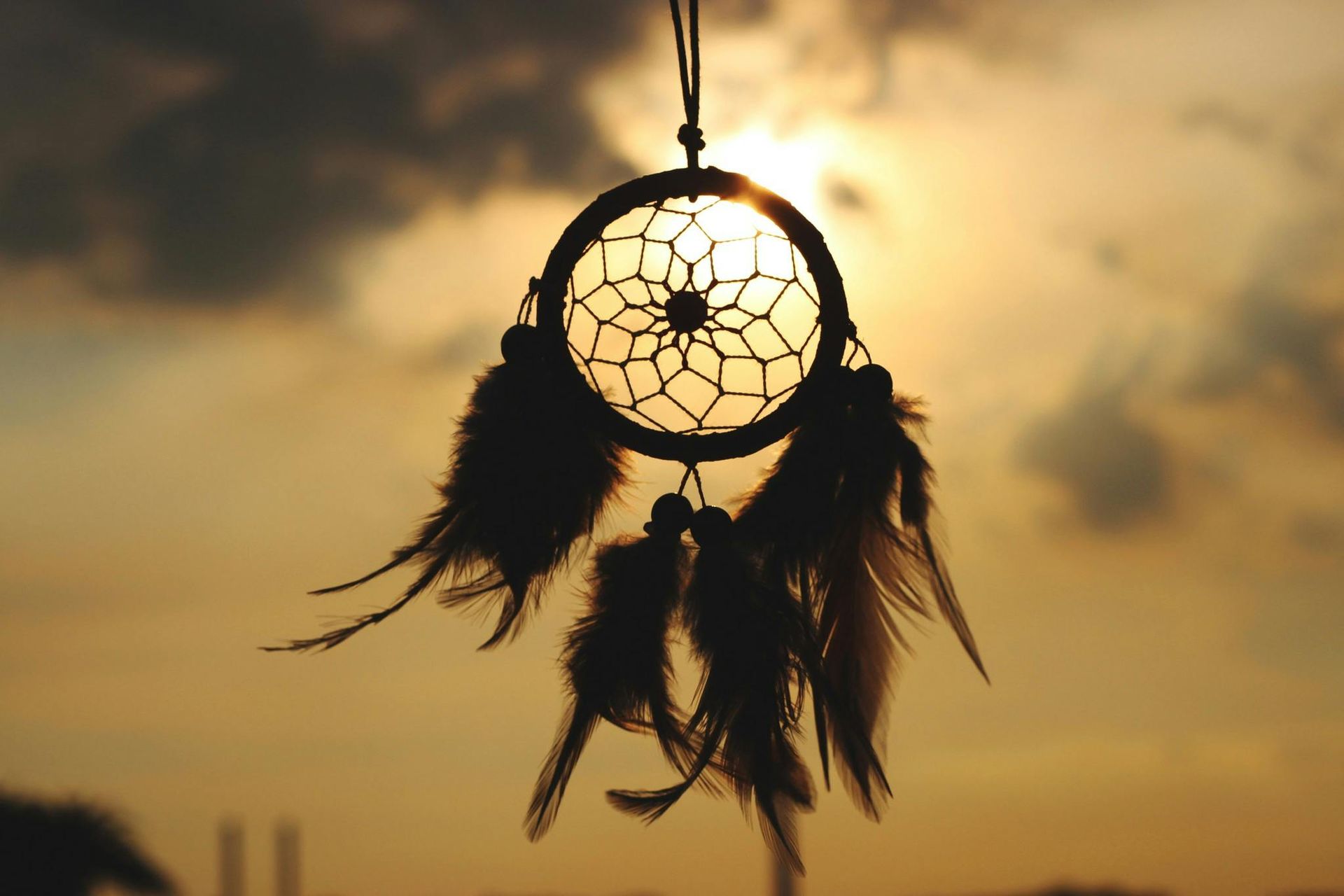 Dreamcatcher inspired by Native American culture hanging in front of the sun.