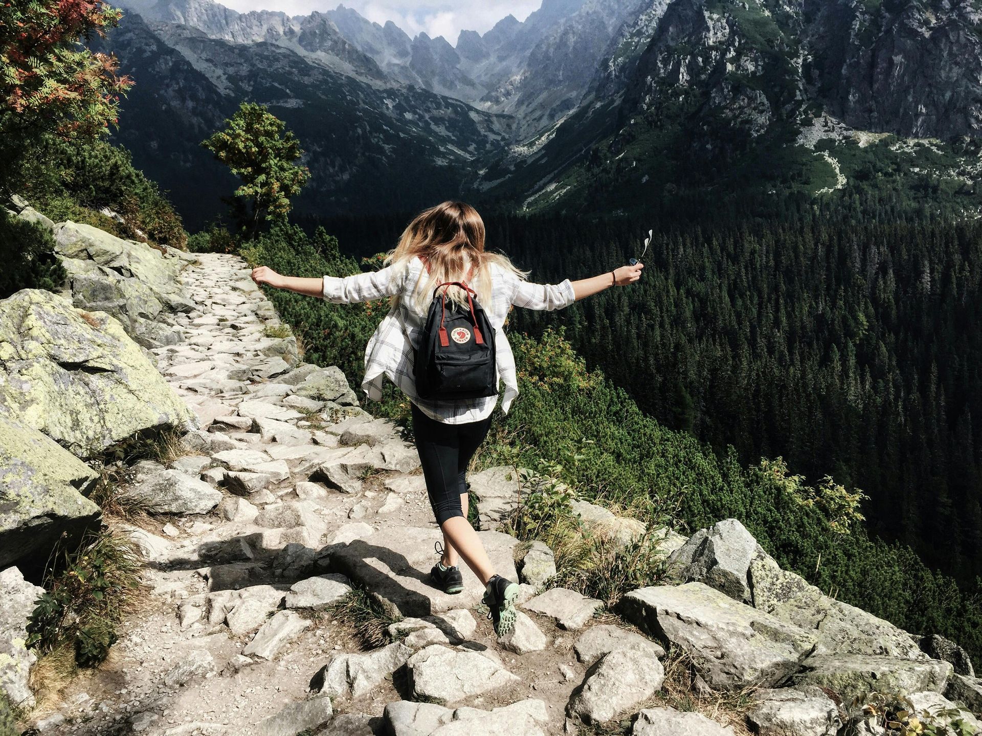 Woman enjoying the outdoors and hiking throughout the pine trees