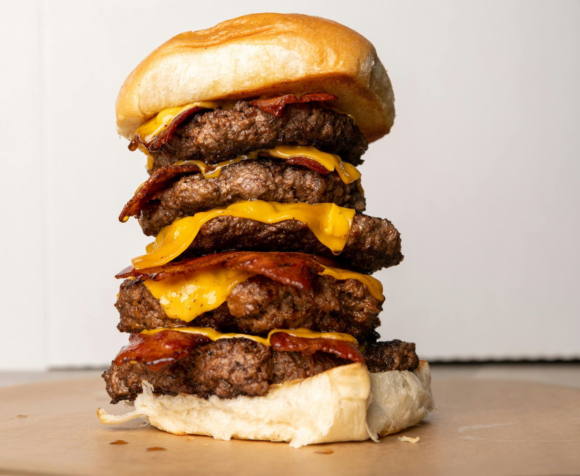 Large stacked buffalo burger with several patties, cheese and bacon
