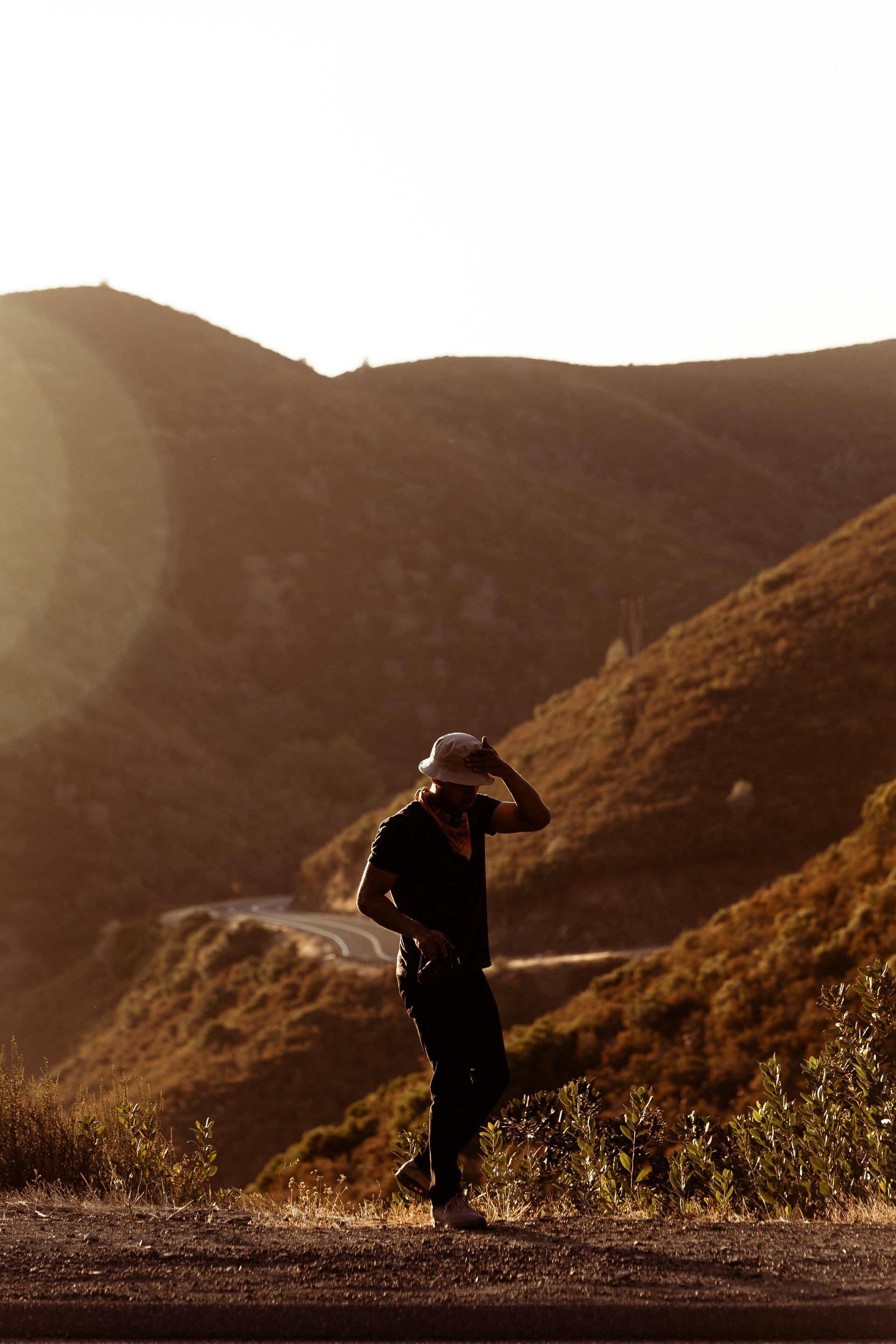 Person hiking in the hills outdoors with the sun shining on them