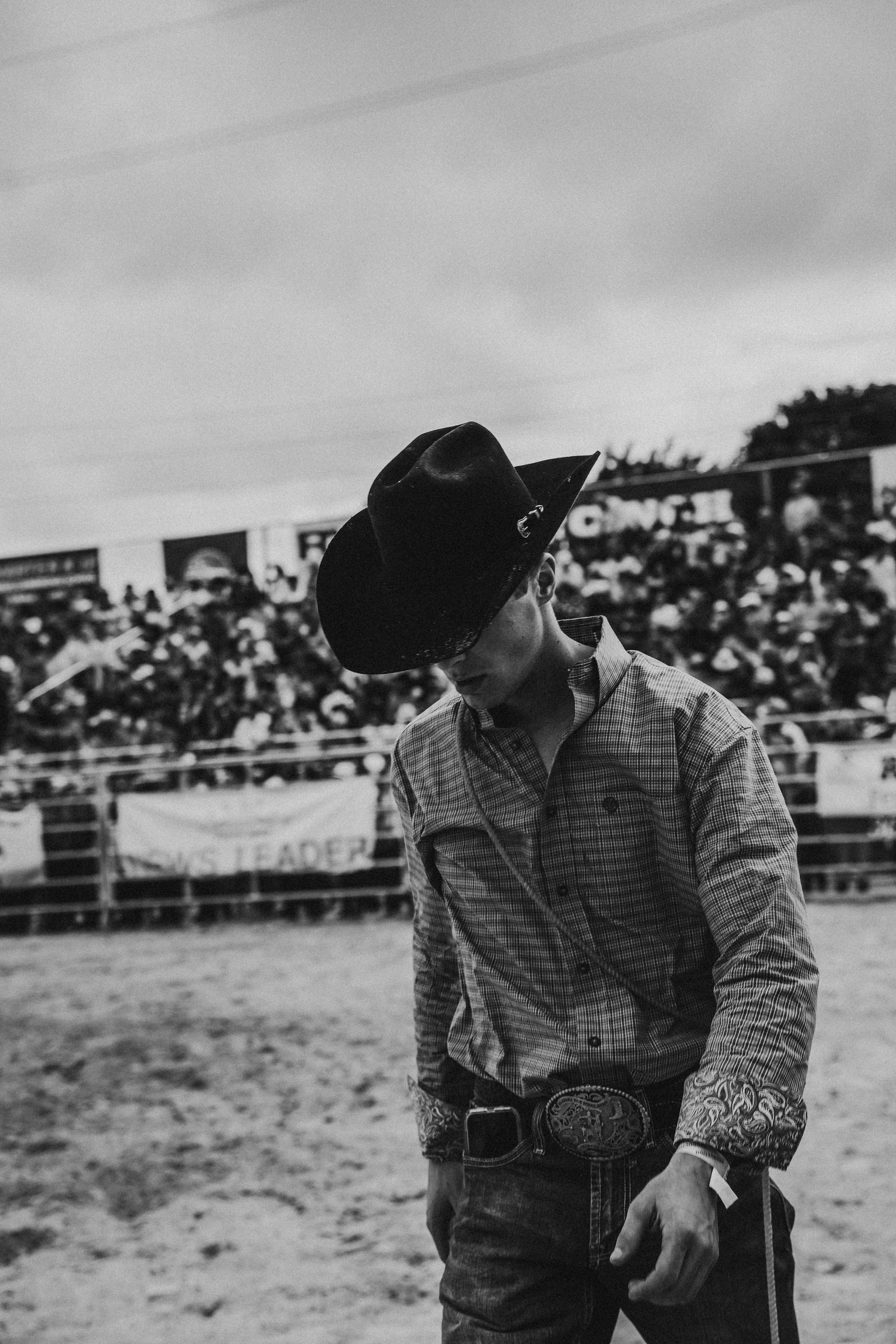 Black and grey photo of a cowboy at rodeo
