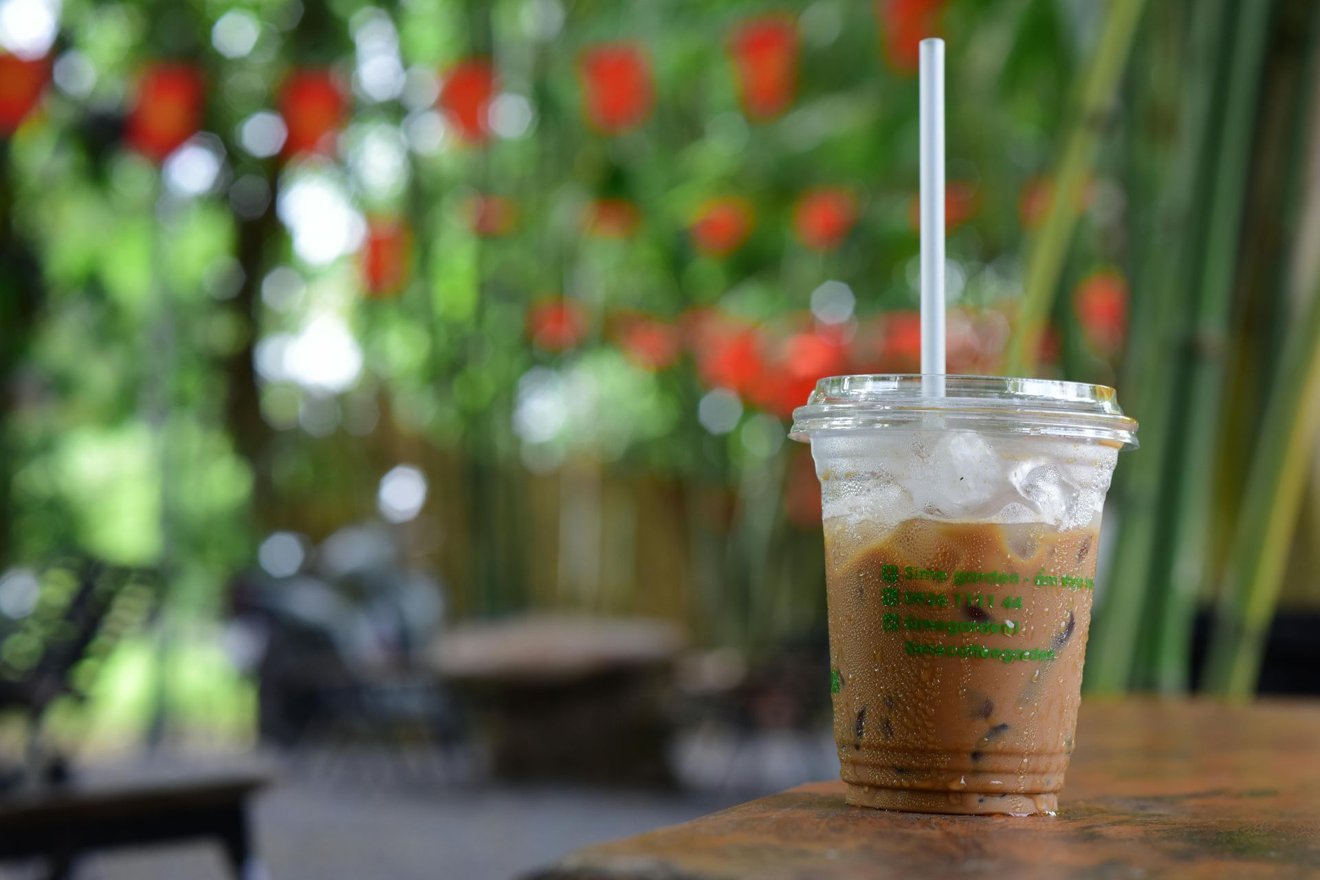 An iced coffee sitting on an outdoor cafe table
