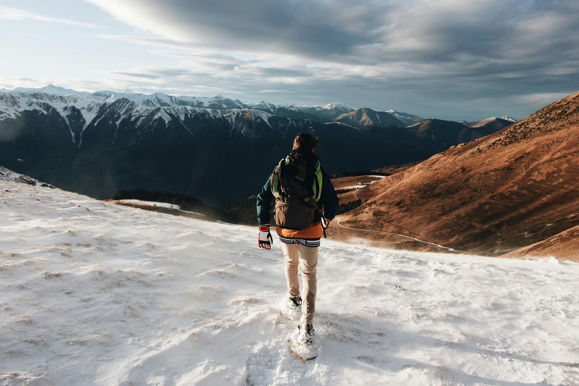 A snowshoer trudging through the snow with their backpack