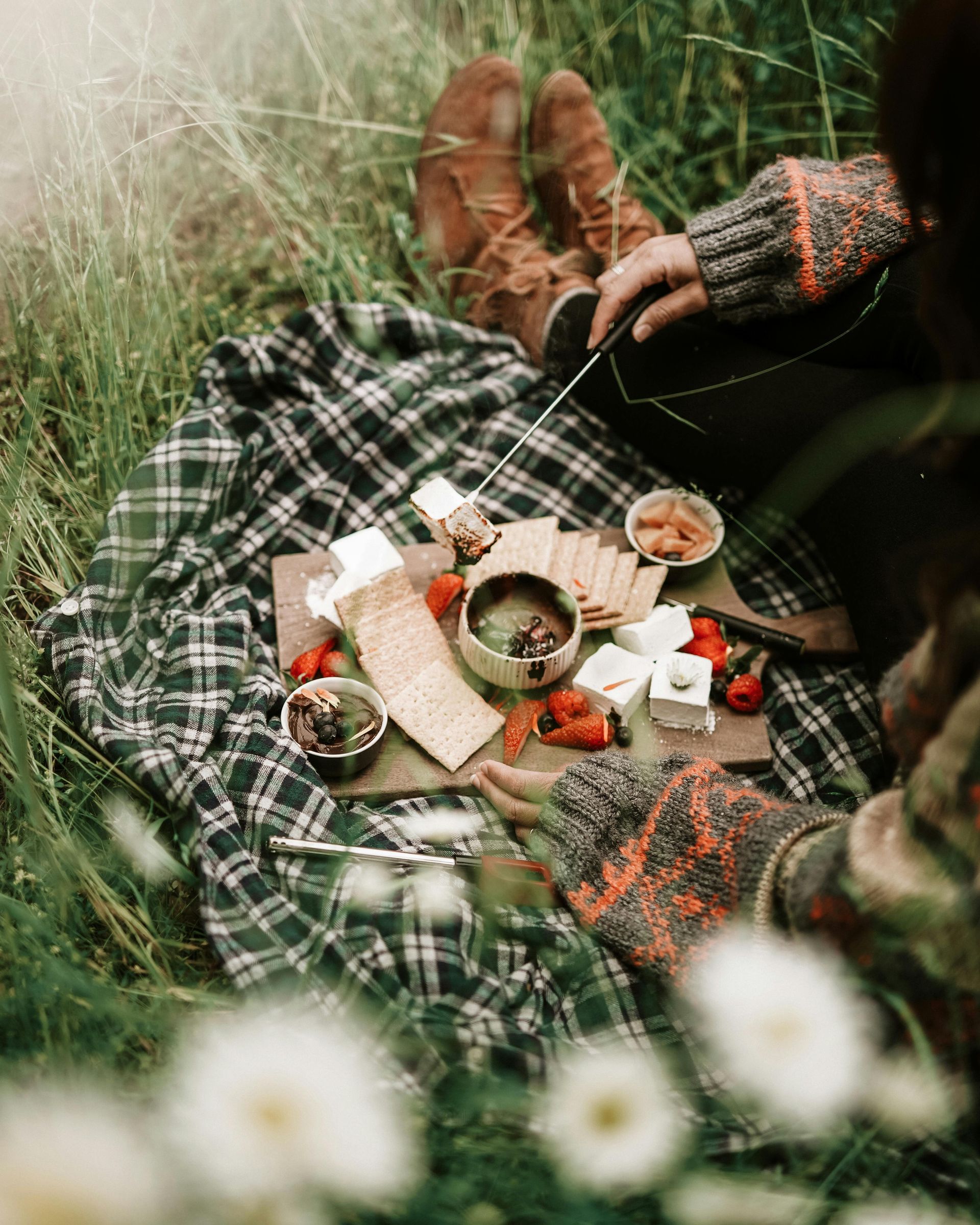 Picnic on a blanket in tall grass in a public town park