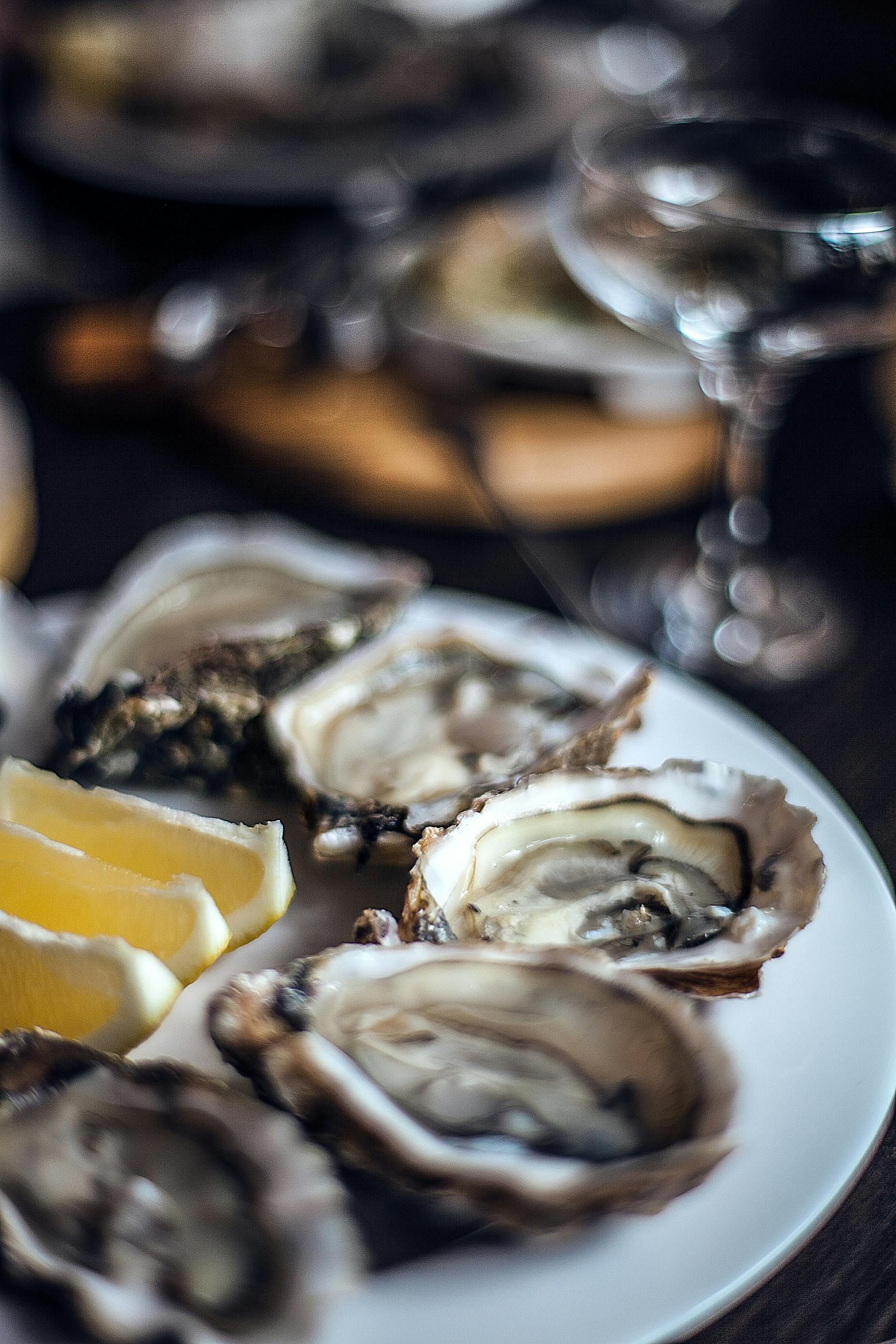 Oysters with lemon platted on a table at a fine dining establishment