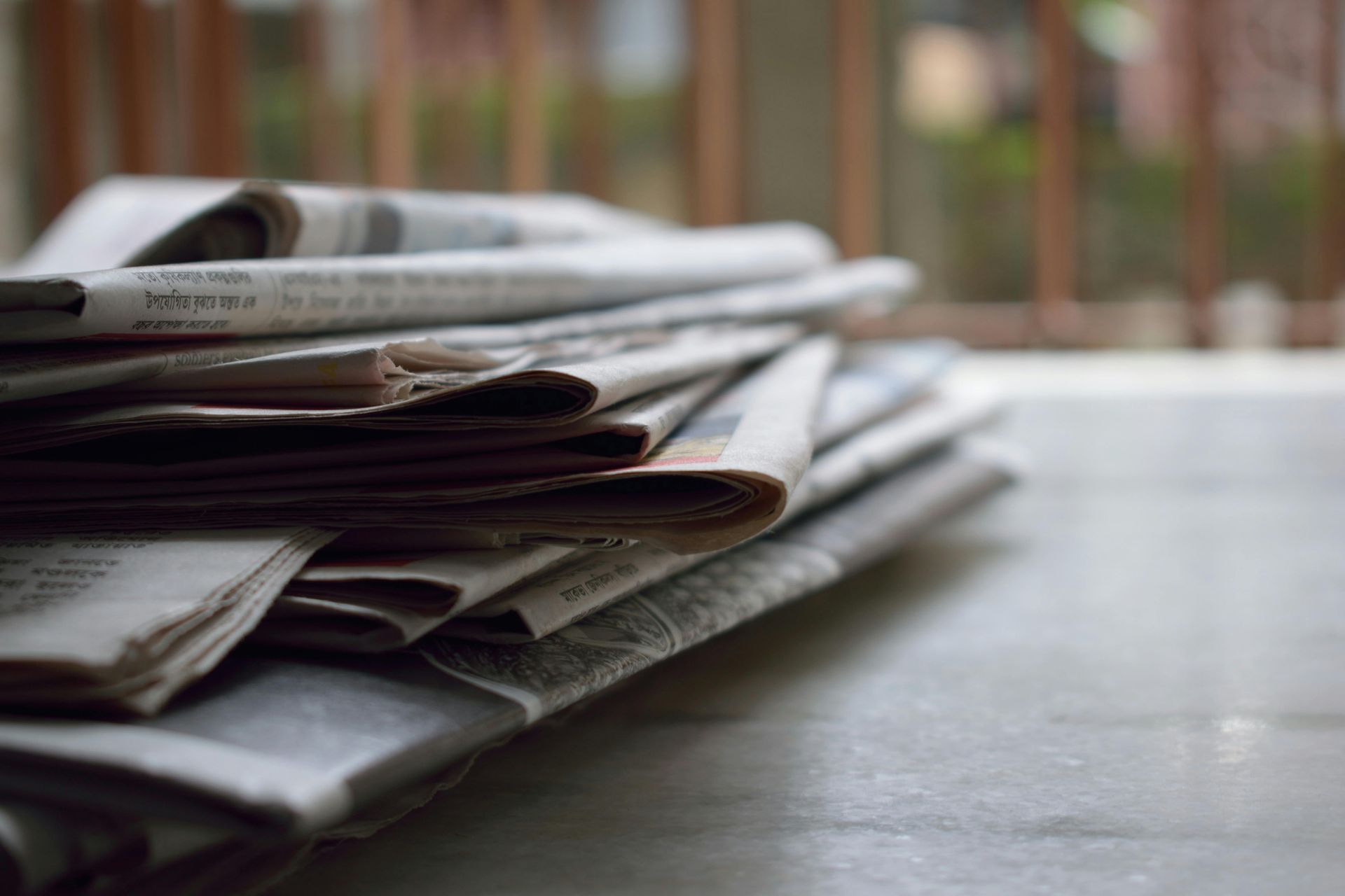 A stack of newspapers and informational guides on a table
