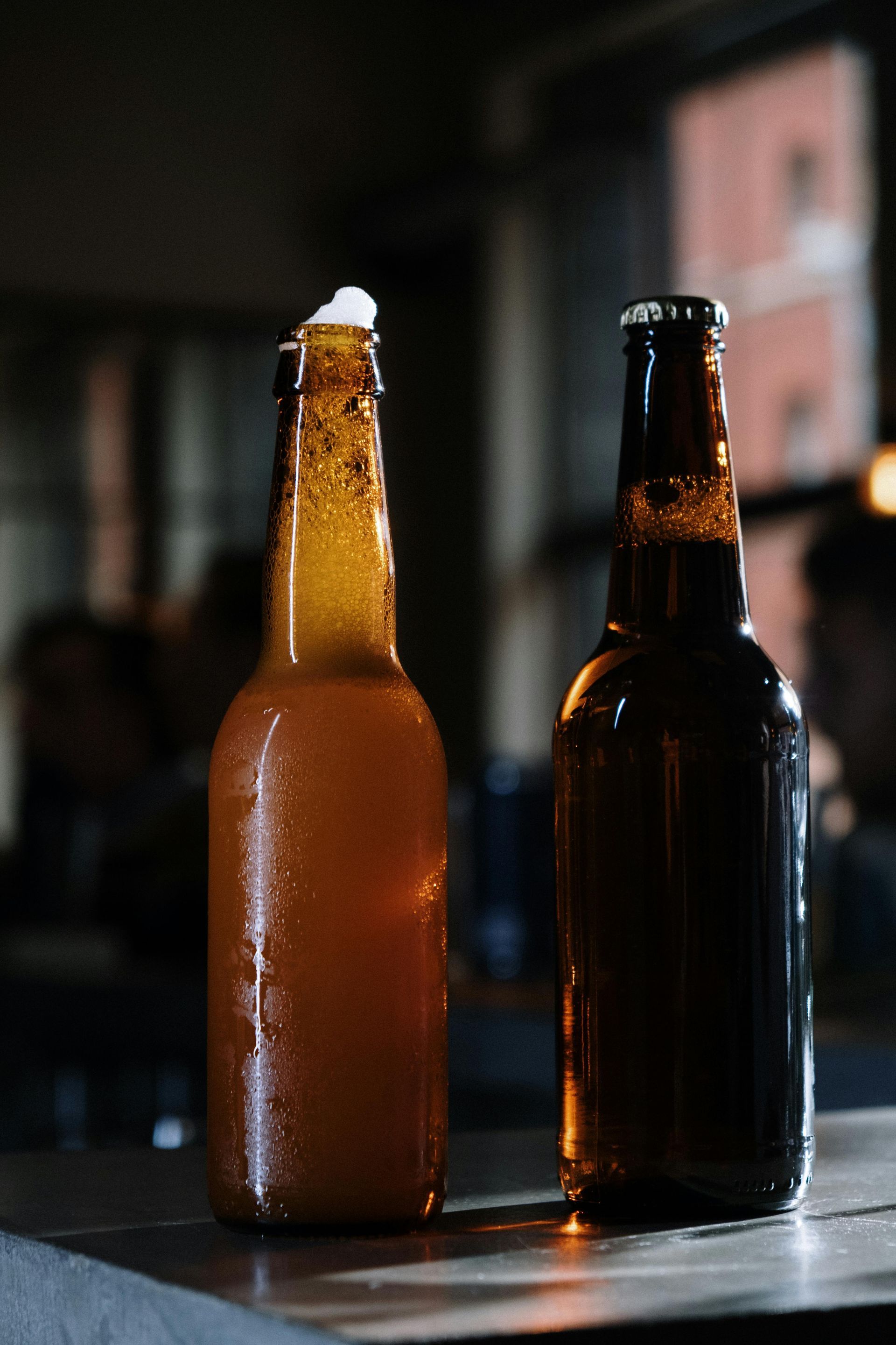 Two cold beers standing side by side in an open bar space