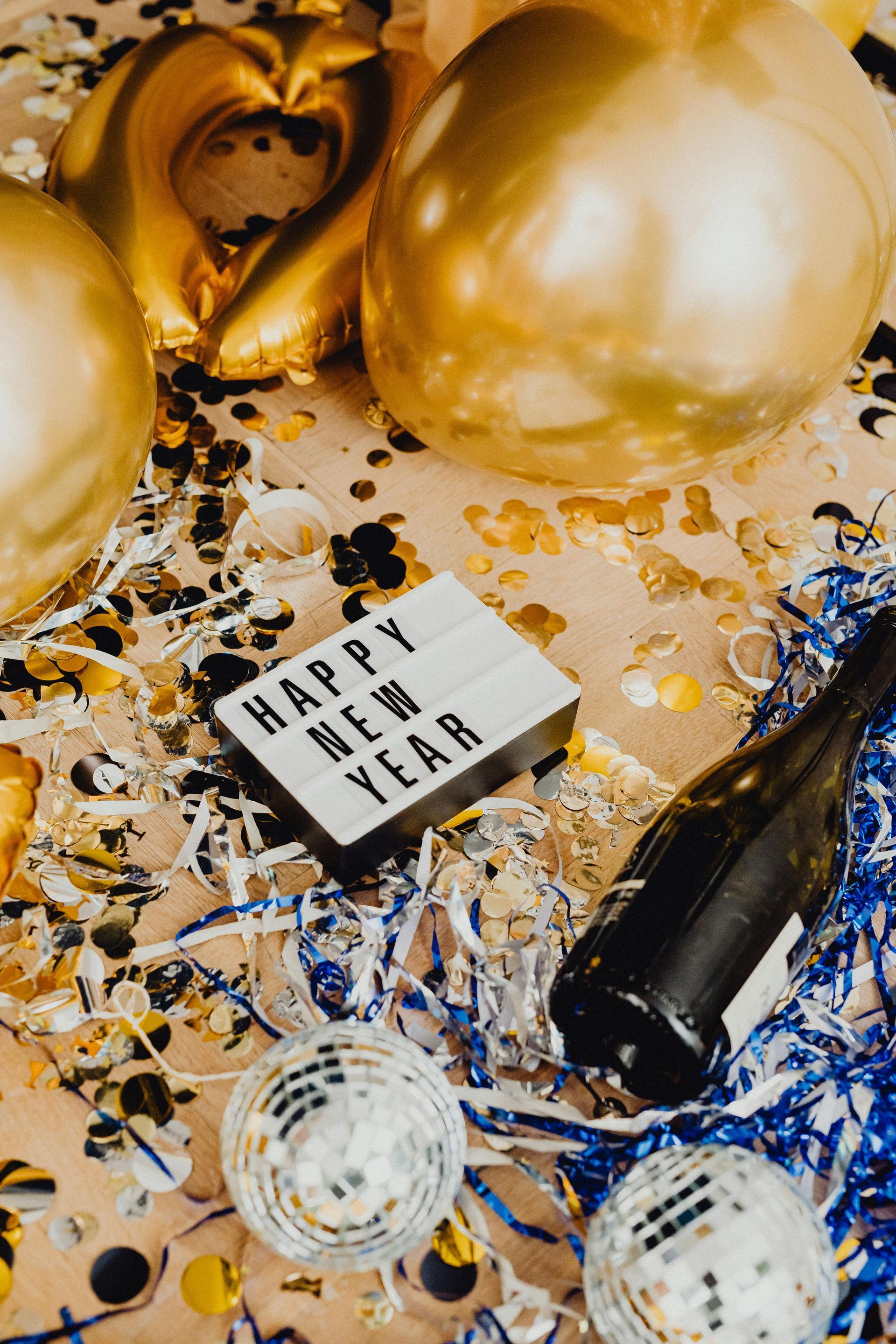 Picture of gold balloons and confetti sitting on table