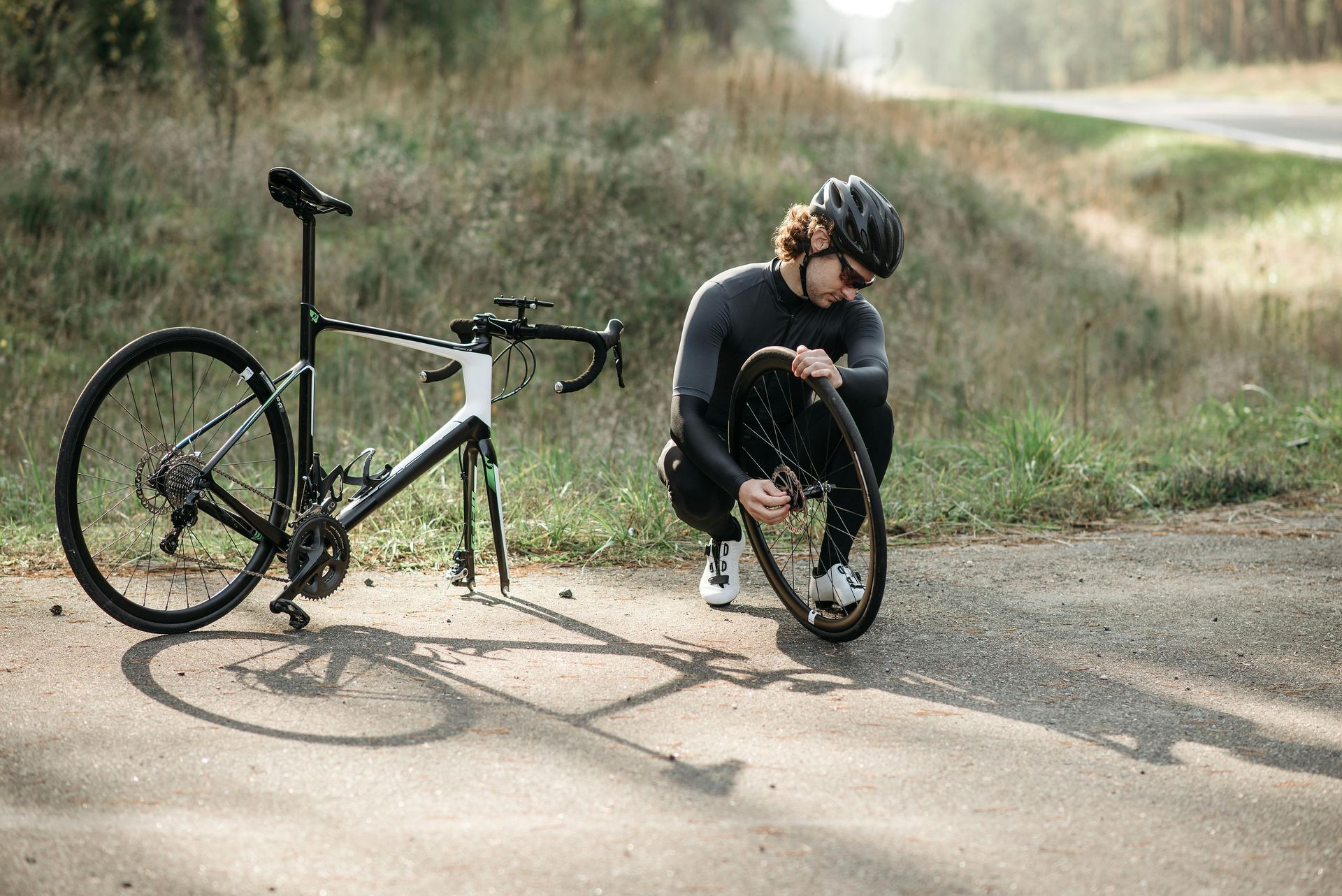 Person fixing front bike wheel off the side of the road