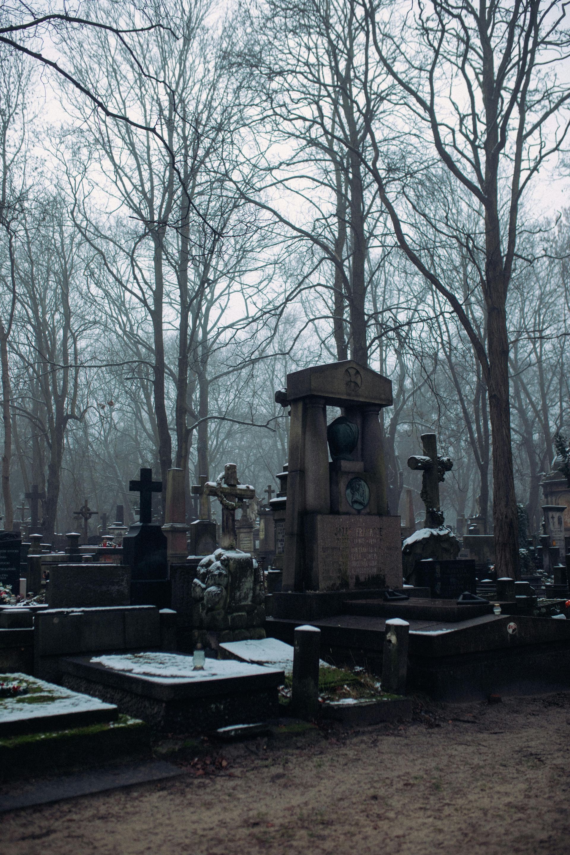 Winter cemetery scene with snow on top of gravestones