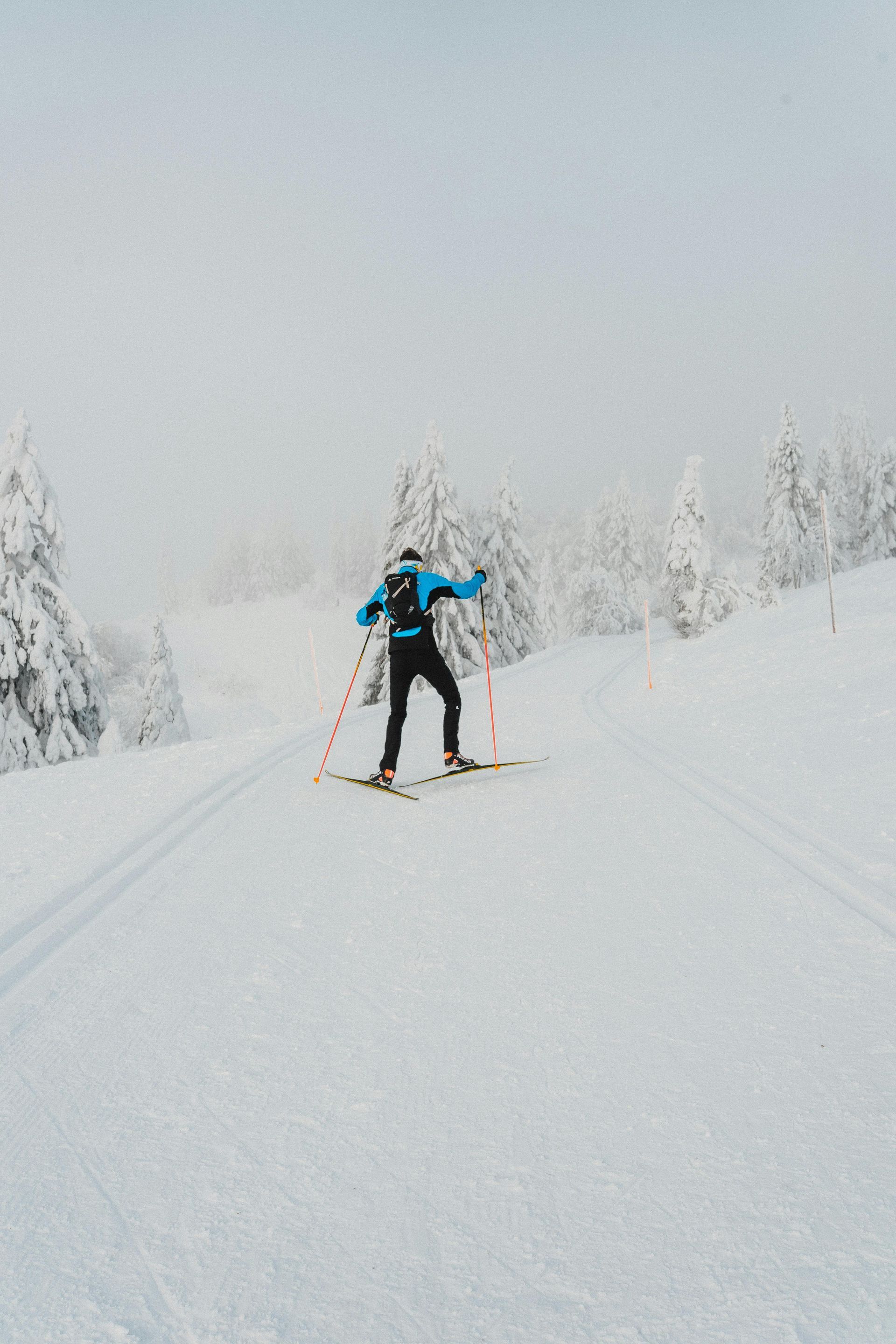 Person cross country in deep snow surrounded by snow covered trees
