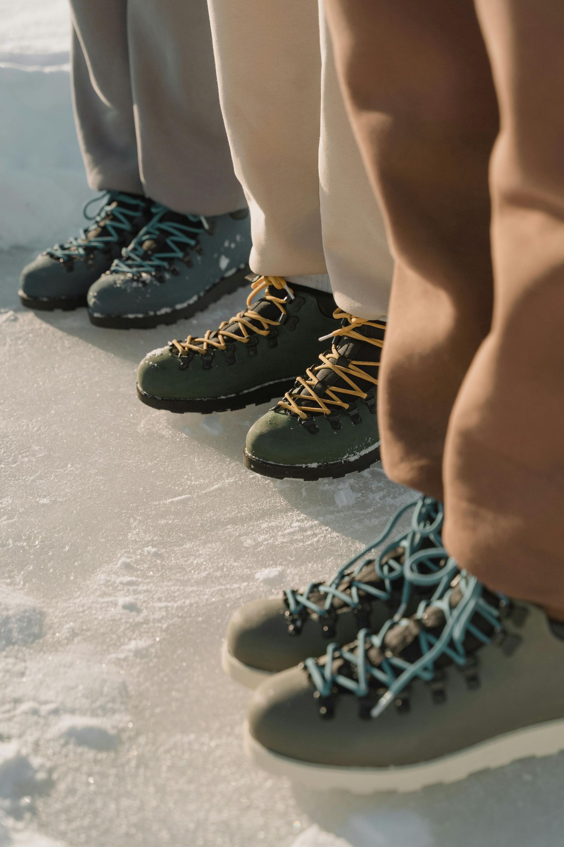 A group of people's warm winter boots in the snow