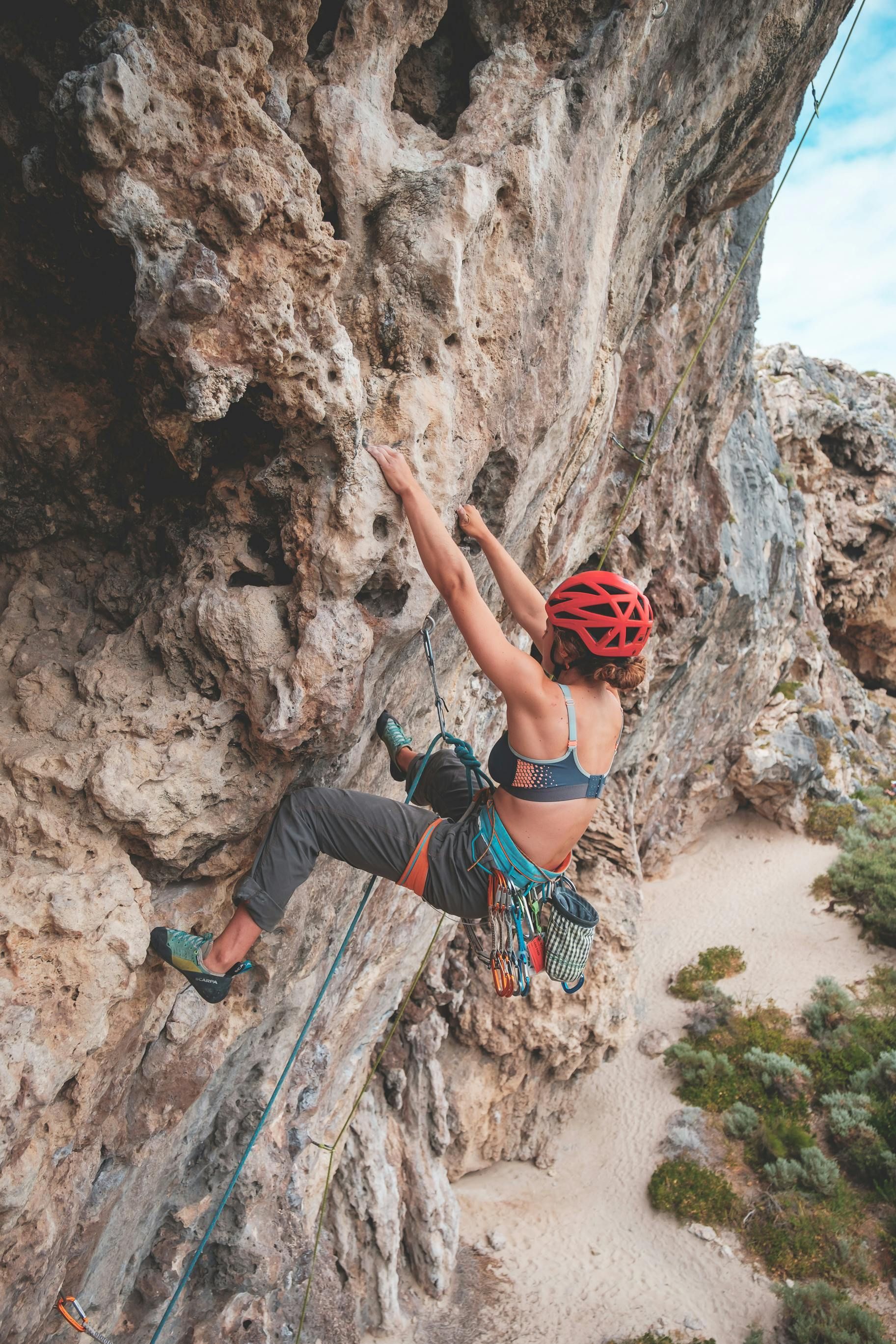 Woman performing rock climbing with safety harness in the desert