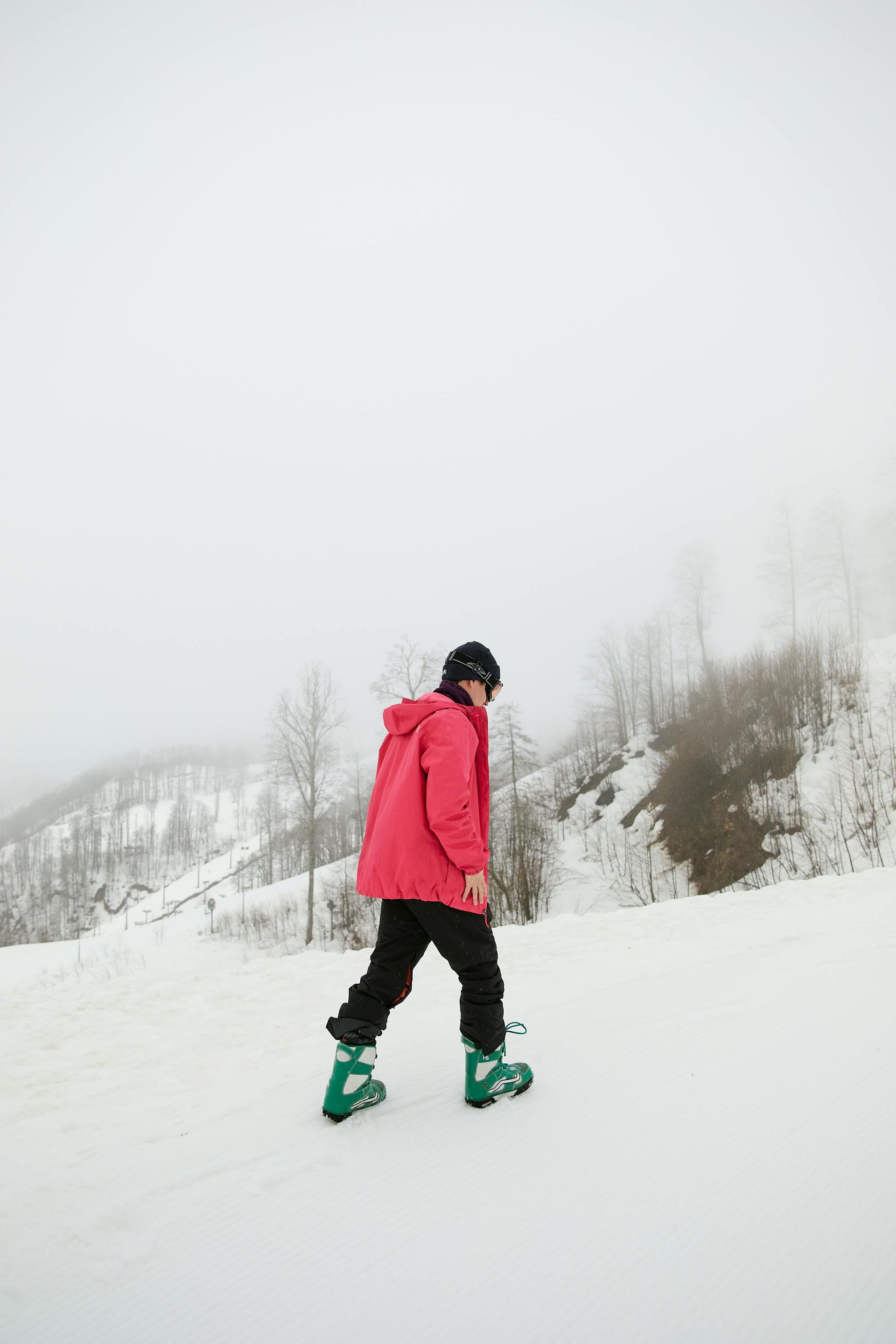 Person hiking through the morning fog on snow covered mountain trails