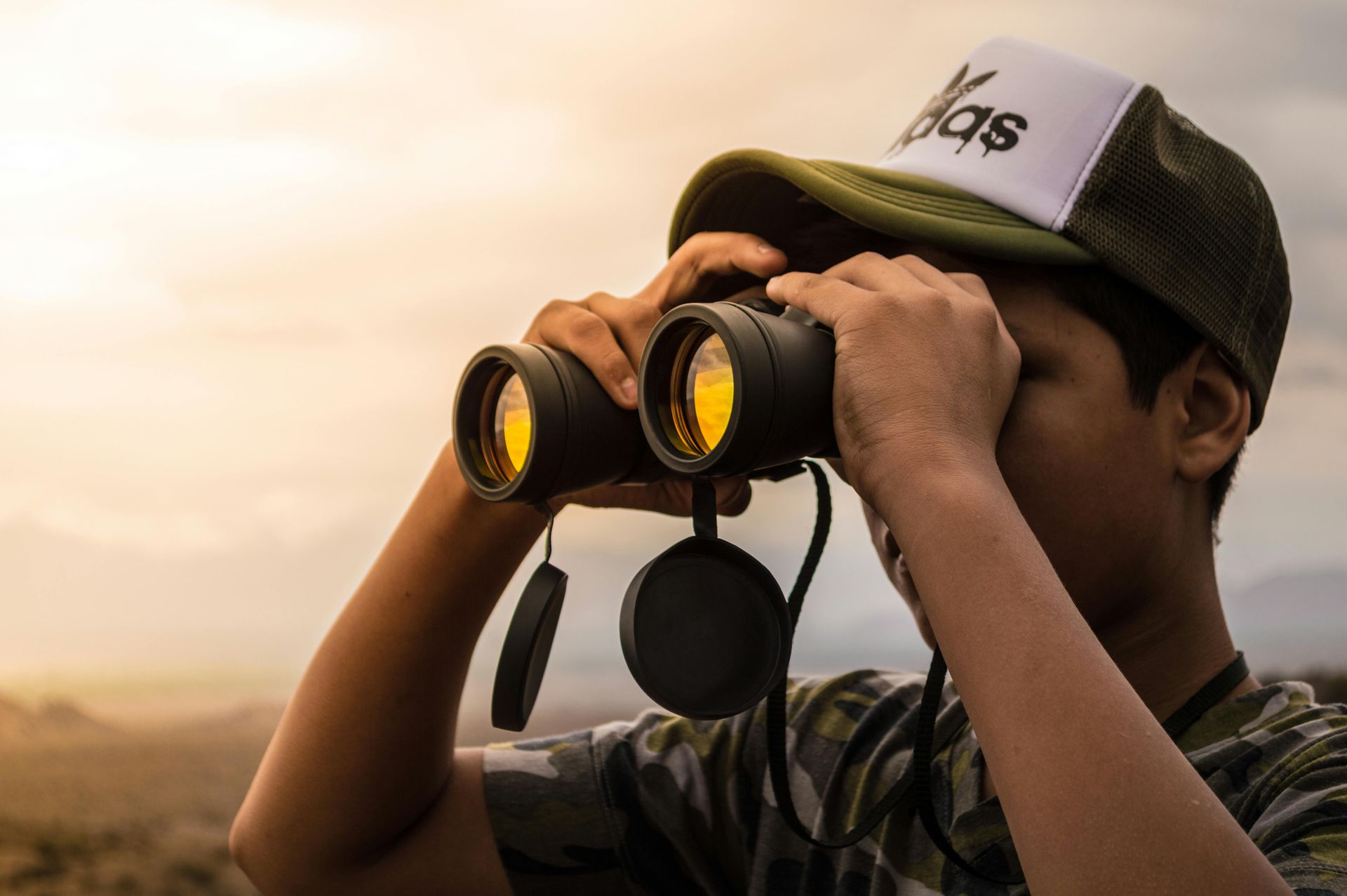 A man looking through binoculars viewing something in the distance