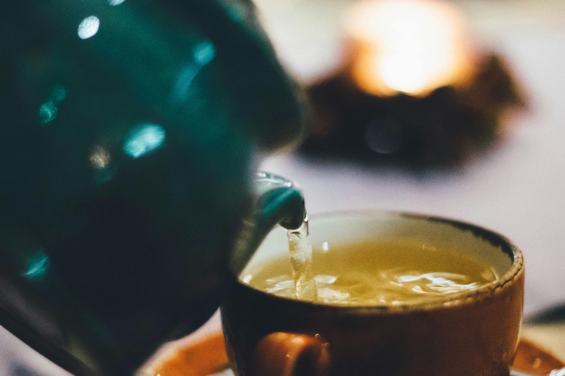Hot water being poured into glass cup to make tea