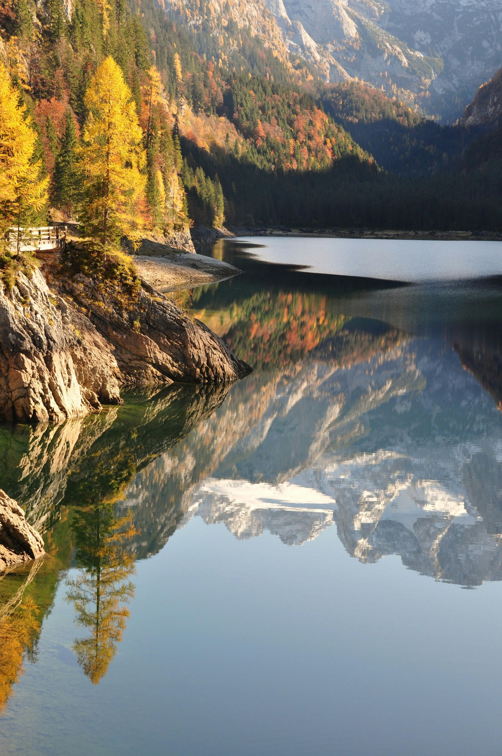 Beautiful lake surrounded by mountains full of changing leaves on trees