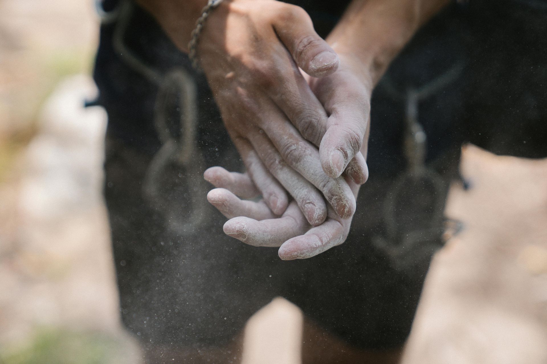 Person putting chalk on their hands before beginning to rock clumb
