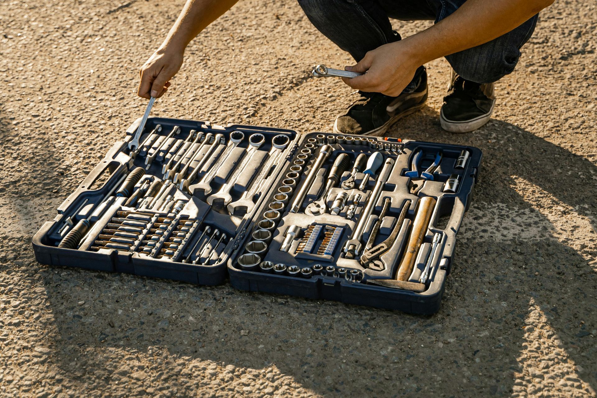 Person with a motorcycle repair kit on the ground