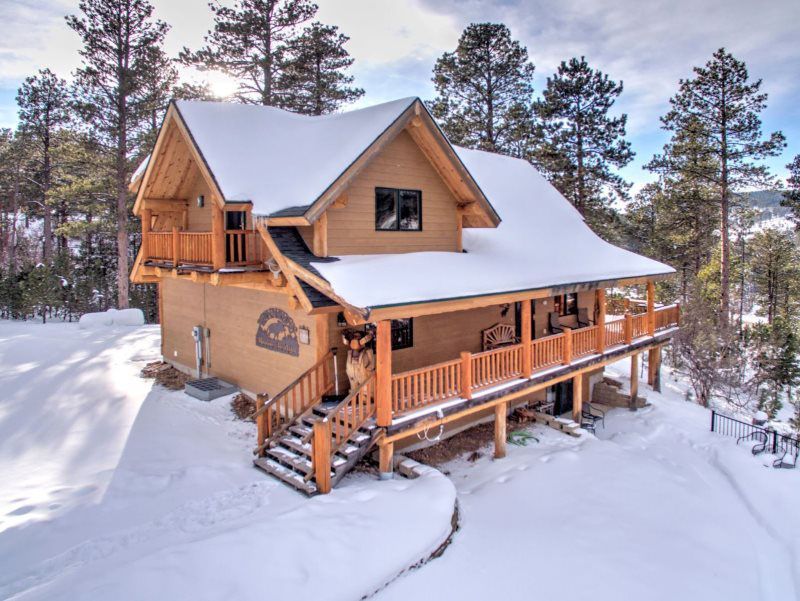 Luxury Deadwood Connections cabin rental in the Black Hills SD covered in snow on a clear, sunny day