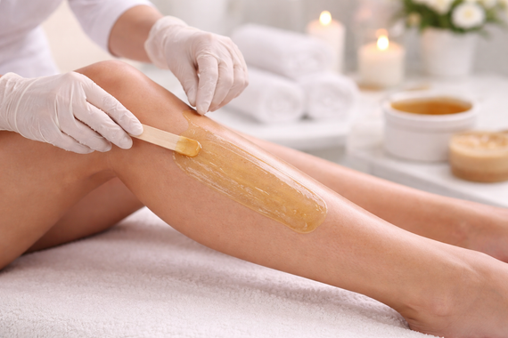 Una persona utiliza un masajeador electrónico portátil de color blanco para el cuero cabelludo en cabello rubio, ya sea en un salón de belleza o en casa.