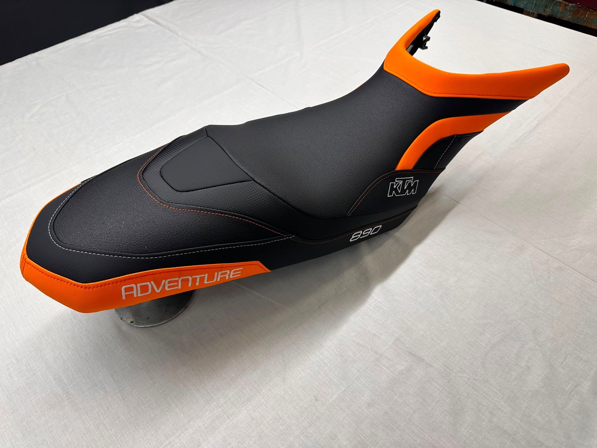 Zapatilla de ciclismo negra y naranja sobre una superficie blanca