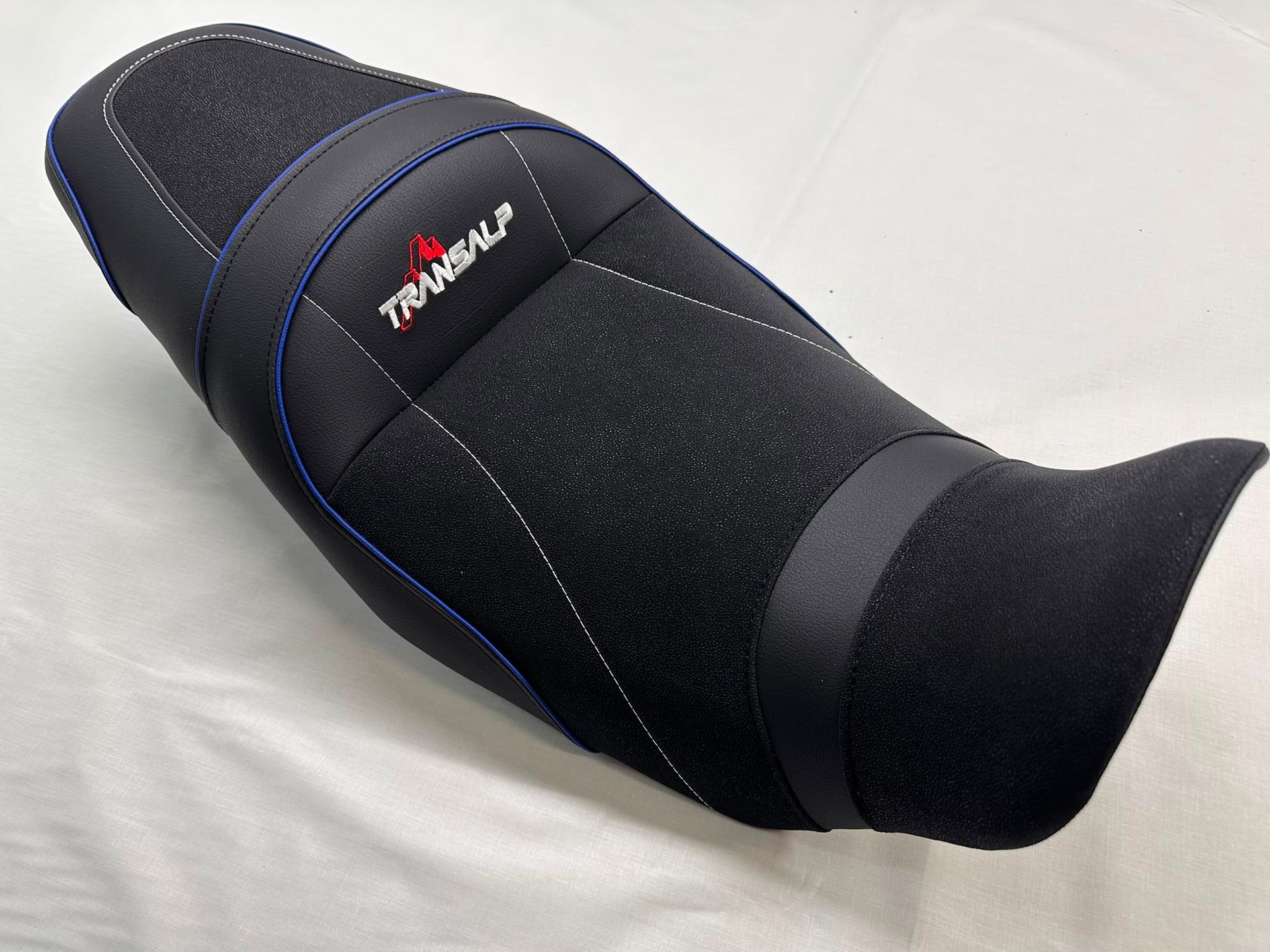 Manga negra de neopreno con costuras azules y un logotipo rojo sobre fondo blanco