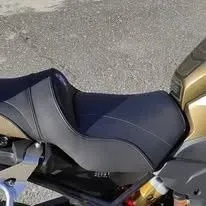 Primer plano del asiento negro de una motocicleta y del panel trasero sobre el pavimento