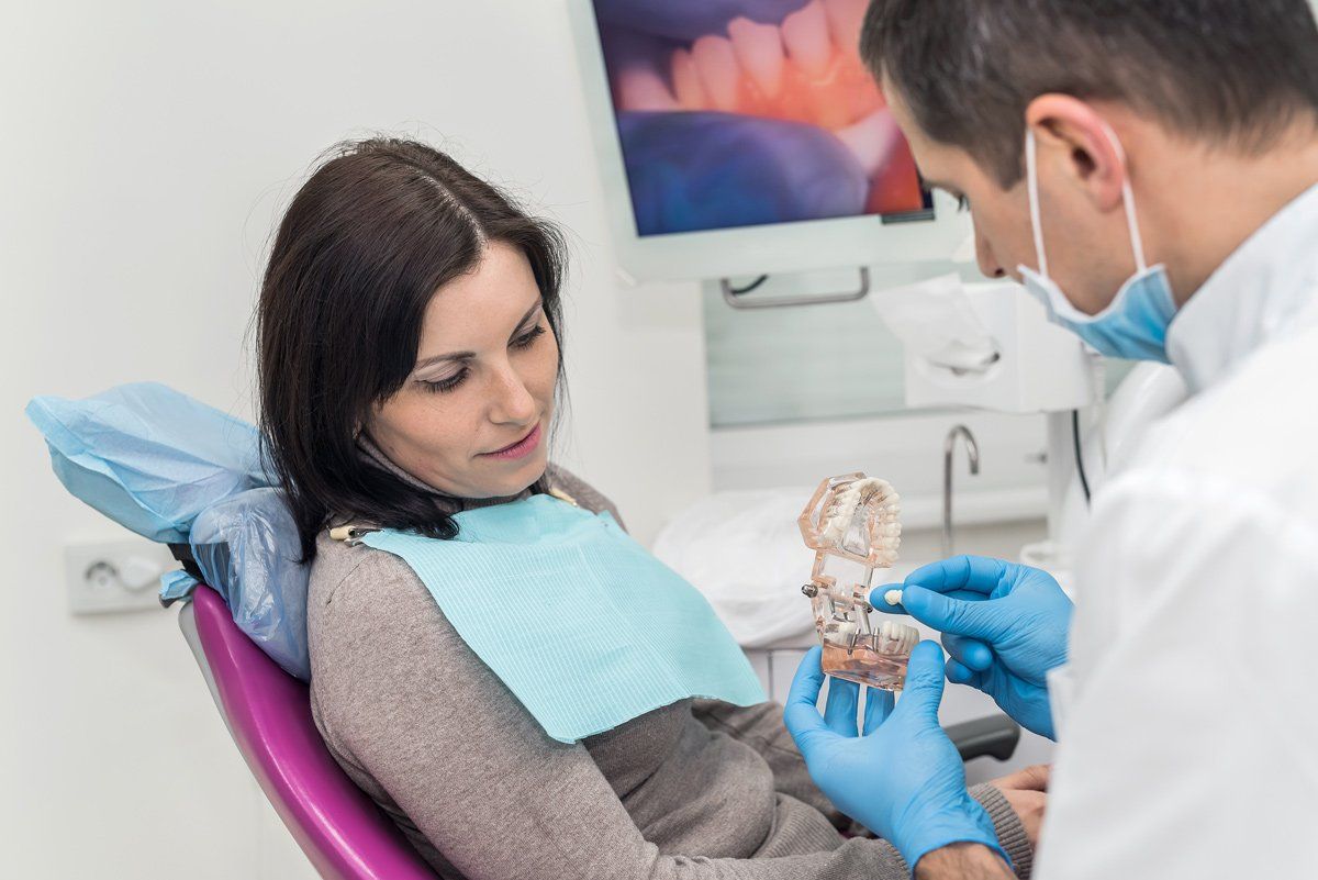 Dentiste expliquant les modèles de couronnes à une patiente