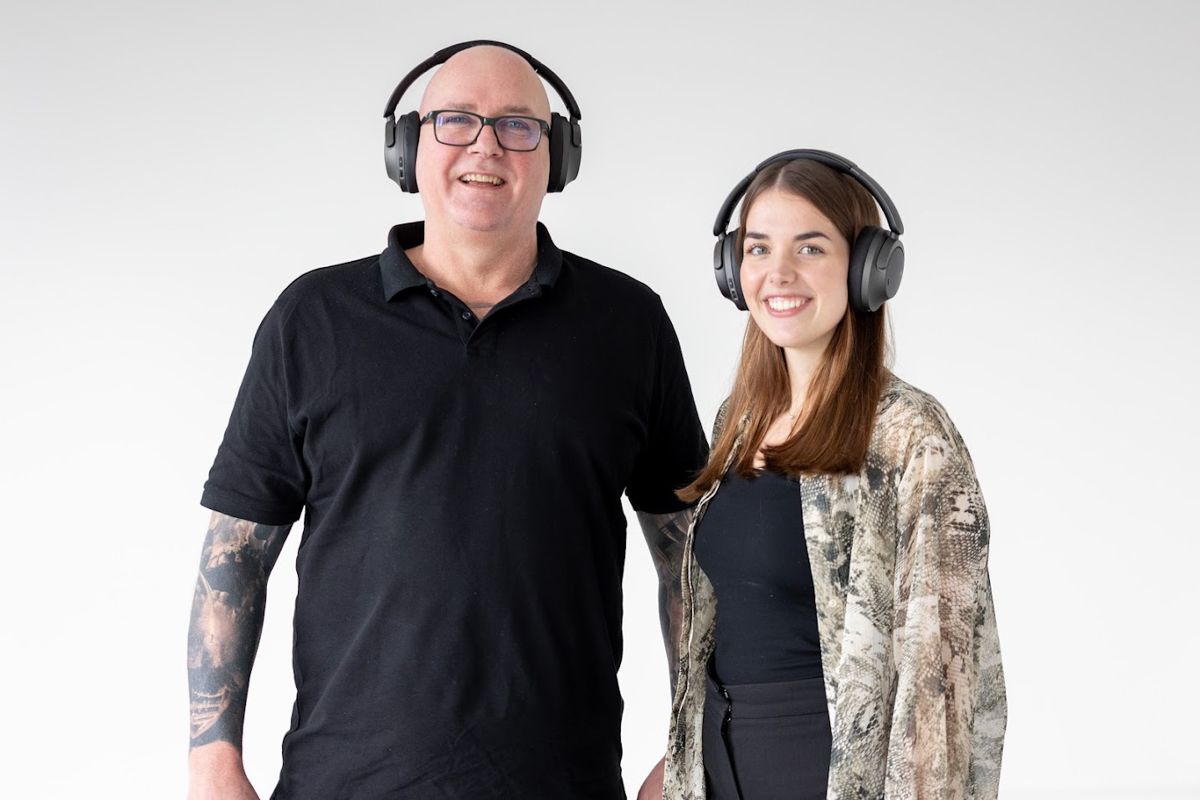 Ein Mann und eine Frau mit Kopfhörern stehen nebeneinander.