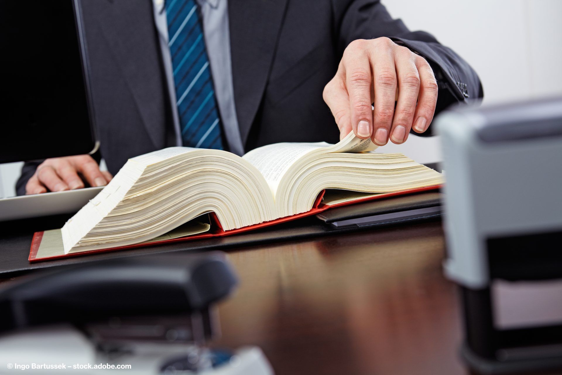 Rechtsanwalt mit einem aufgeschlagenen Gesetzbuch
