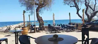 Una mesa y sillas están sentadas en la playa cerca del océano.