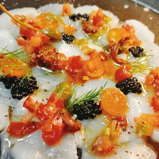 Un primer plano de un plato de comida con tomates y moras.