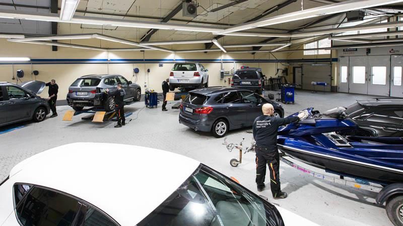 Ein Mann arbeitet in einer Garage an einem Auto.