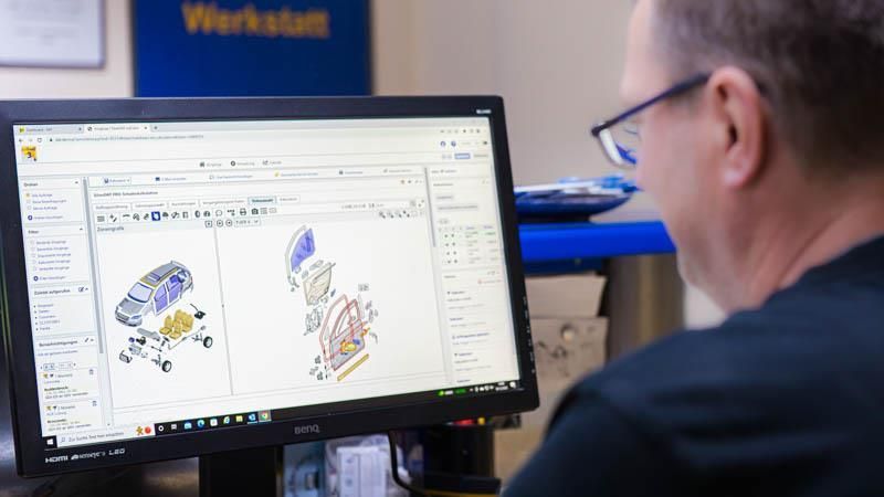Ein Mann sitzt vor einem Computerbildschirm.