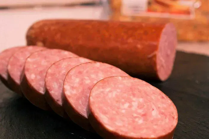 Un primer plano de una salchicha cortada en rodajas sobre una mesa.