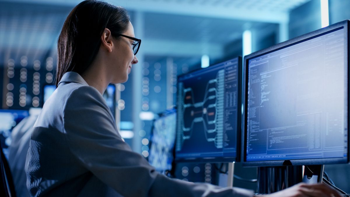 eine Frau arbeitet an einem Computer in einem Serverraum .