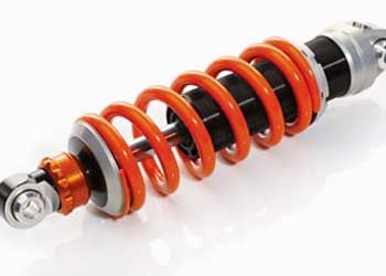 Amortecedor de motocicleta laranja e preto com mola helicoidal.