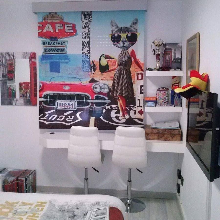 Dormitorio blanco con mural de gato de estilo pop art, dos sillas blancas, estantes, espejo y esquina de la cama visible
