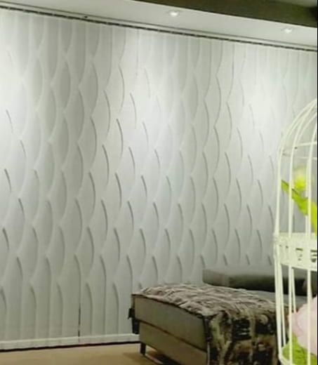 Pared blanca texturizada del dormitorio con una cama y una cuna blanca en el lado derecho.