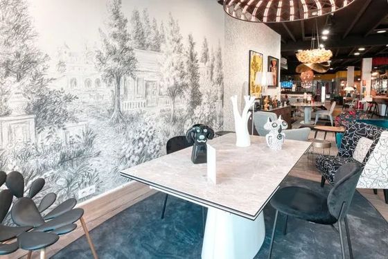 Salle à manger design avec table contemporaine et fresque murale en noir et blanc, ambiance showroom déco haut de gamme.