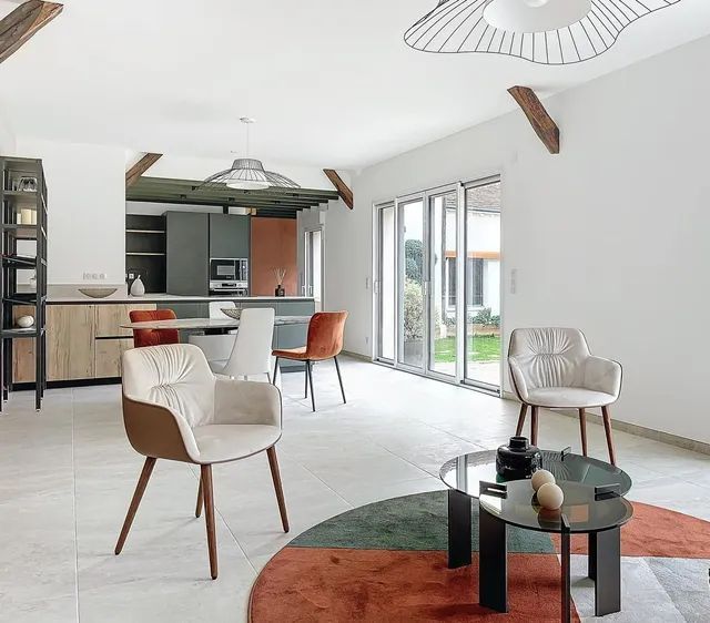 Salon moderne avec cuisine ouverte, grandes baies vitrées et espace lumineux