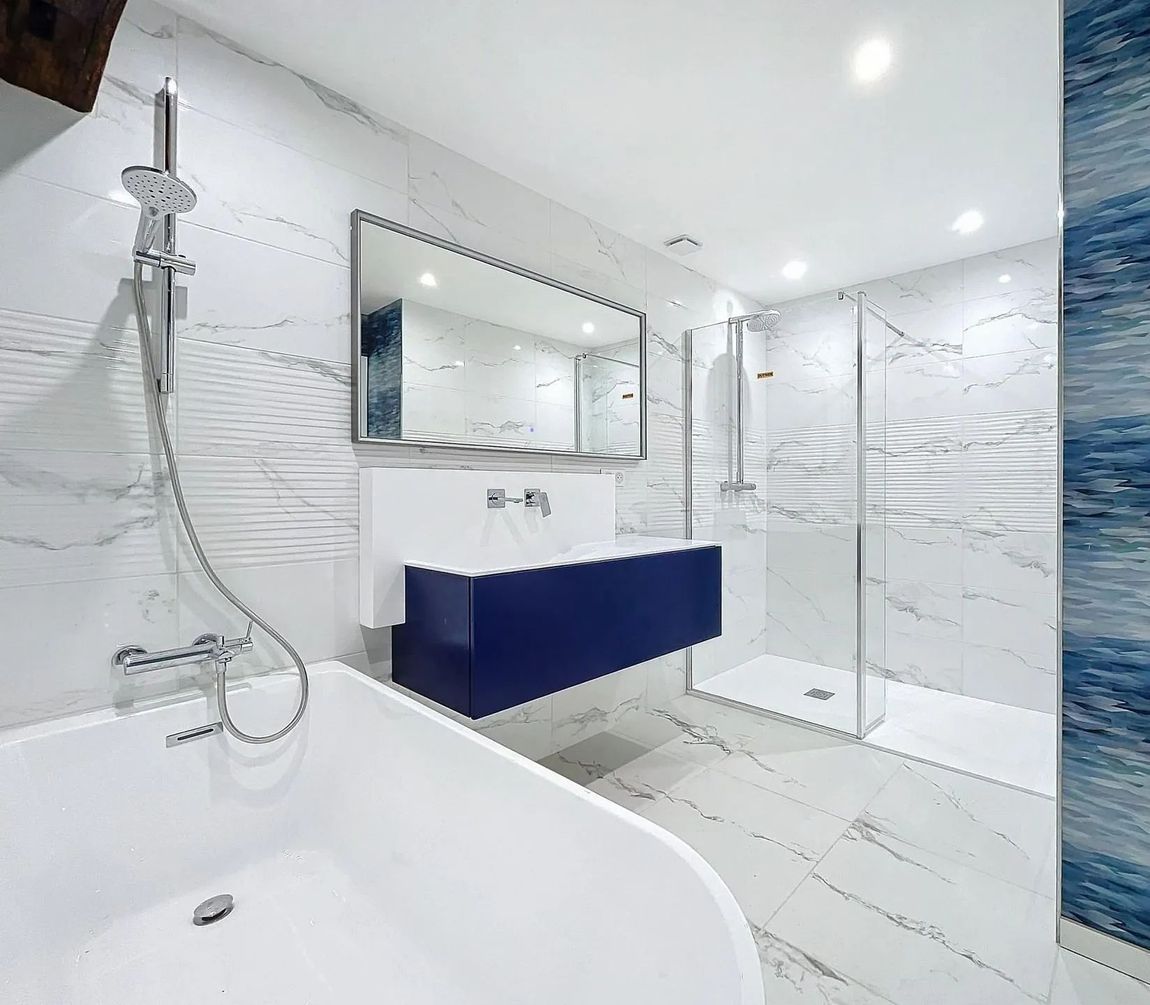 Salle de bains moderne avec douche à l’italienne, baignoire et meuble vasque suspendu bleu