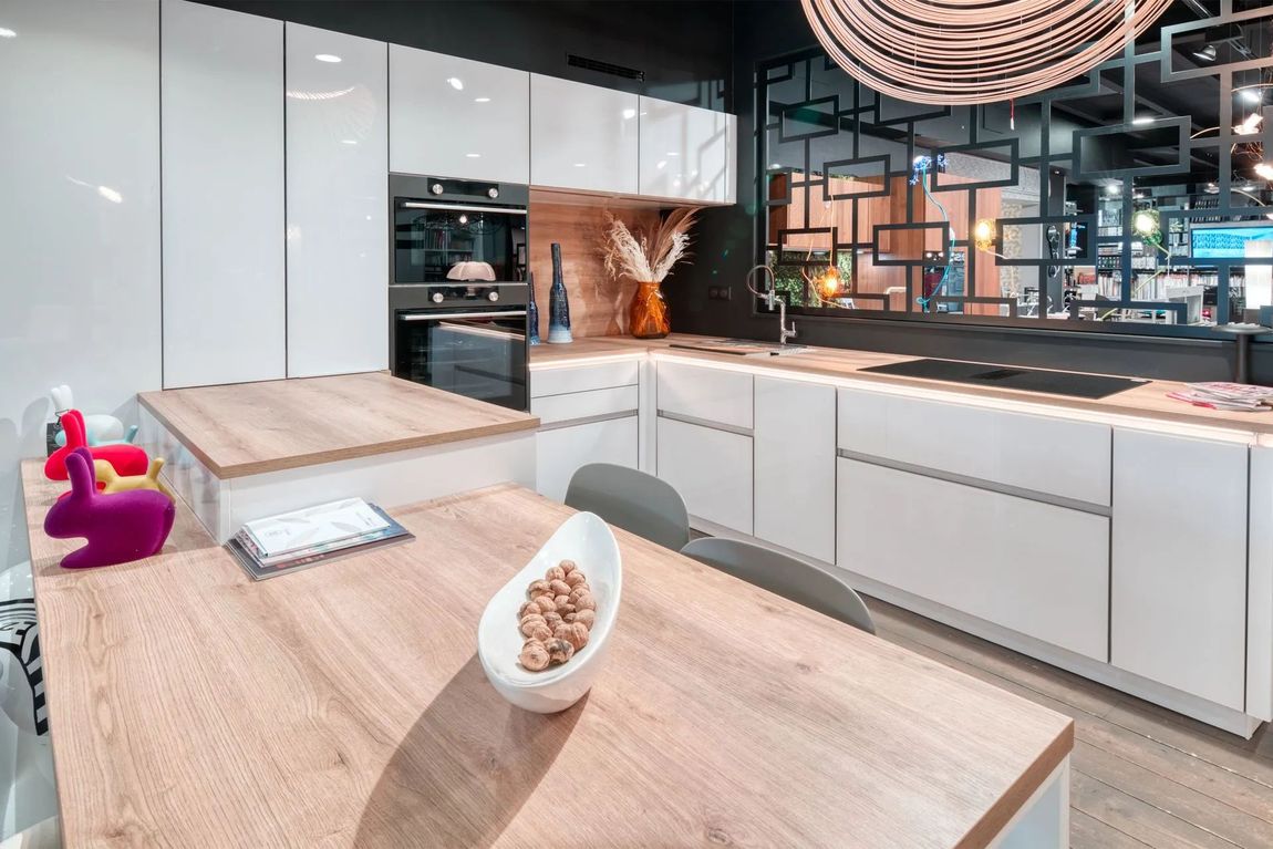 Showroom de cuisines modernes avec îlot central, rangements intégrés et éclairage design