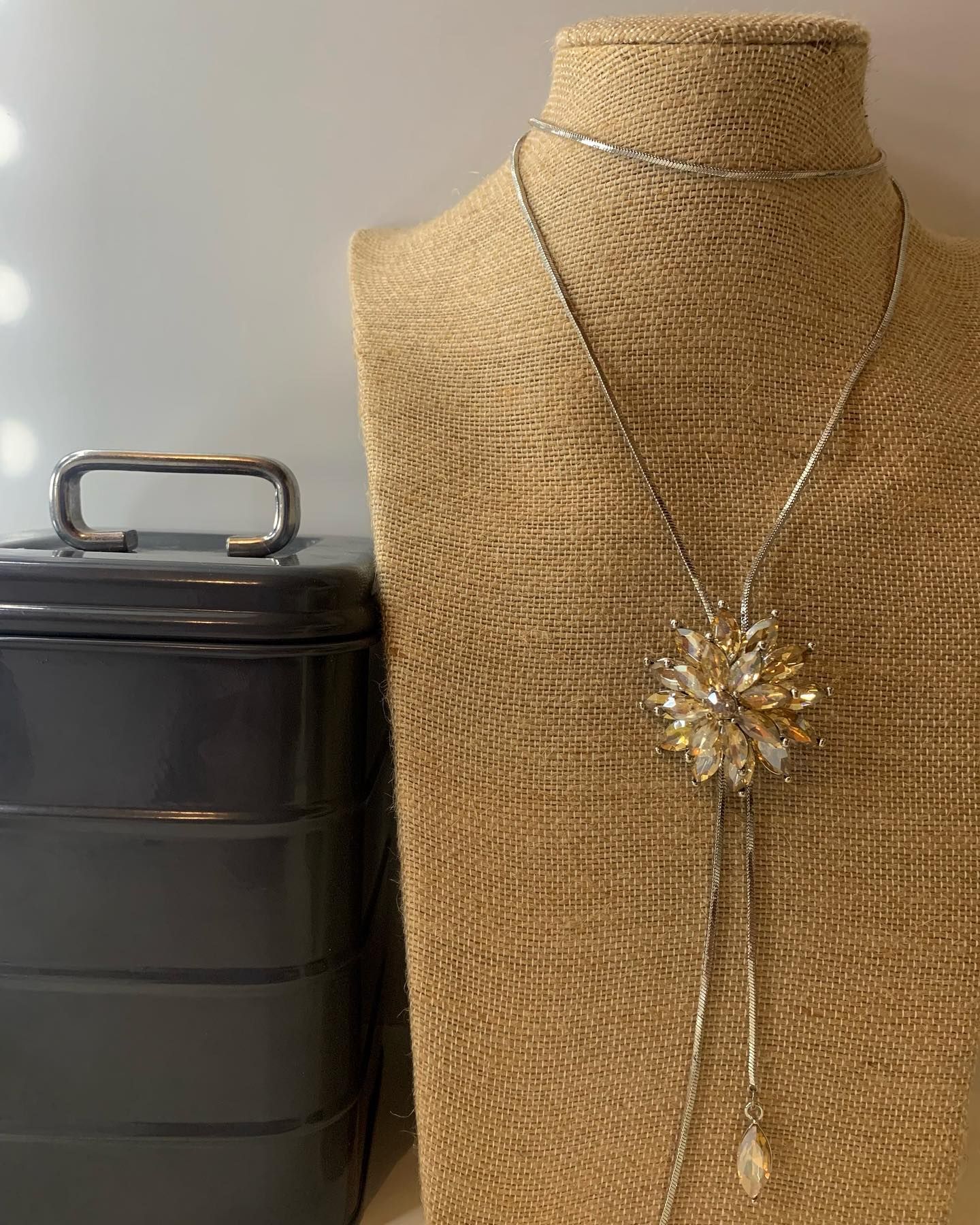 Un collar está en un maniquí al lado de una caja gris.